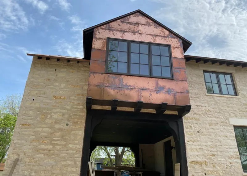 Copper metal panel facade on a stone building for Skylight Installation in West Little River